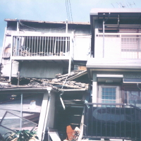 阪神大震災で、同じ見た目でも強さが違い、隣家によりかかってしまった倒壊建物のイメージ